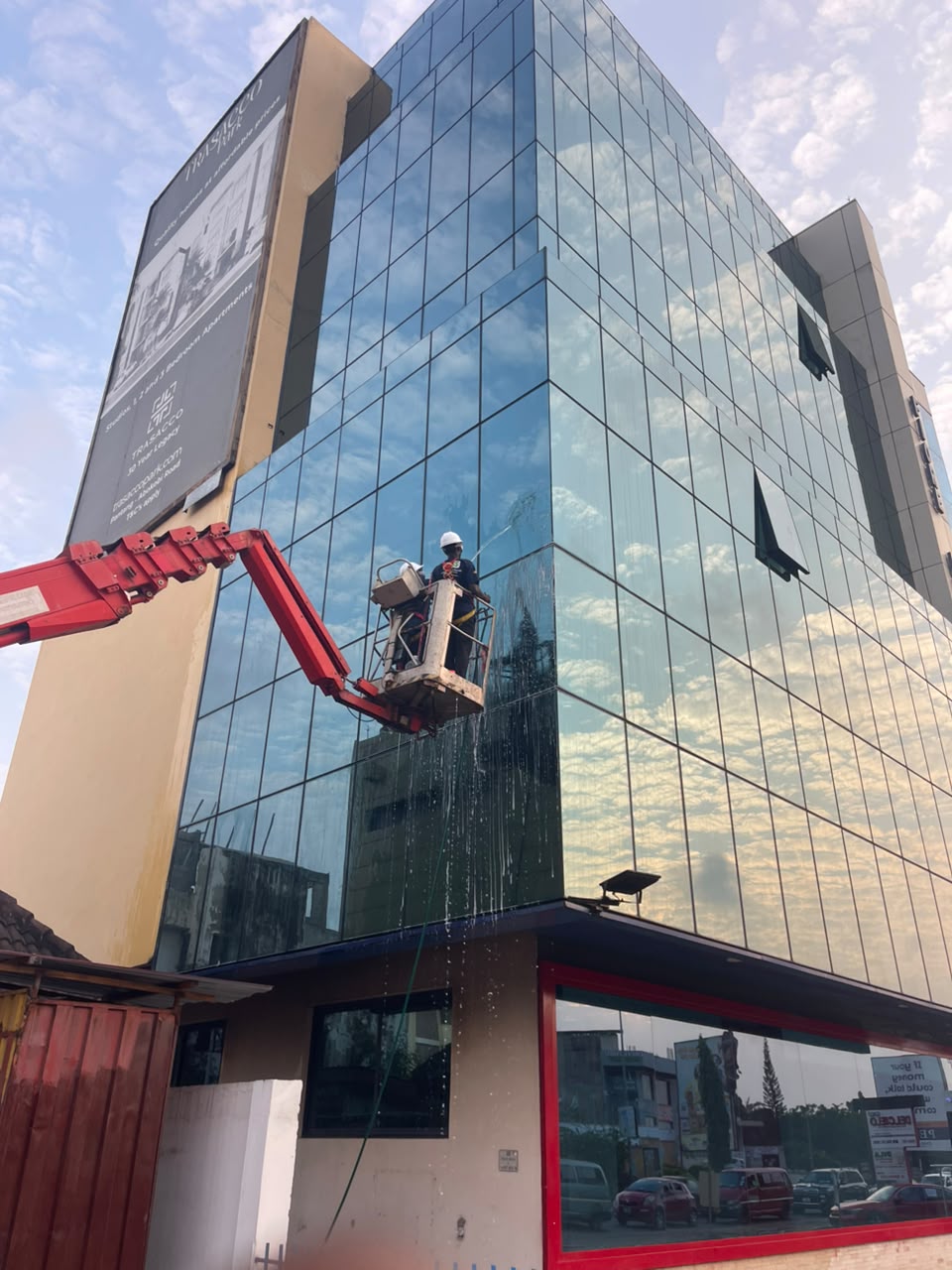 HFJS cradle cleaning a high-rise glass facade